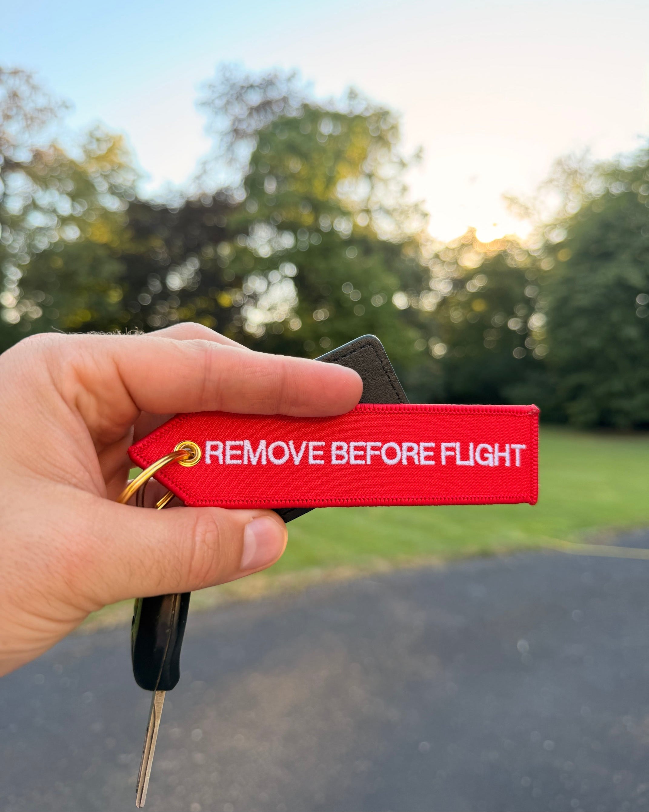 Roter "Remove before Flight" Schlüsselanhänger mit goldenem Ring im Aviation Style